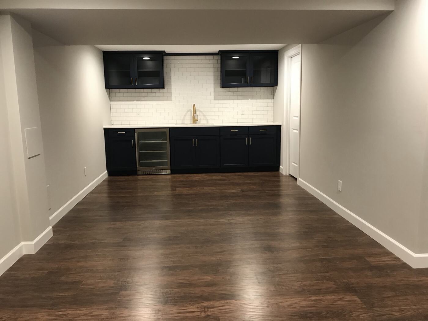 Finished lower level with custom wet bar and wood flooring